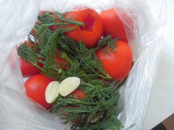 Färskt saltade tomater i en påse och en kastrull