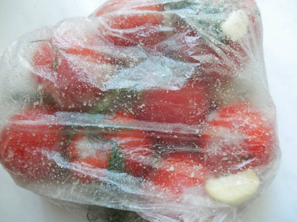 Färskt saltade tomater i en påse och en kastrull